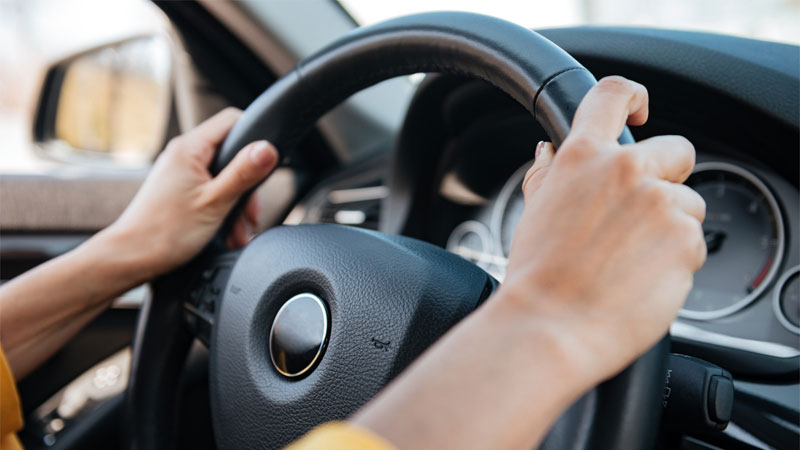 womans hands on steering wheel